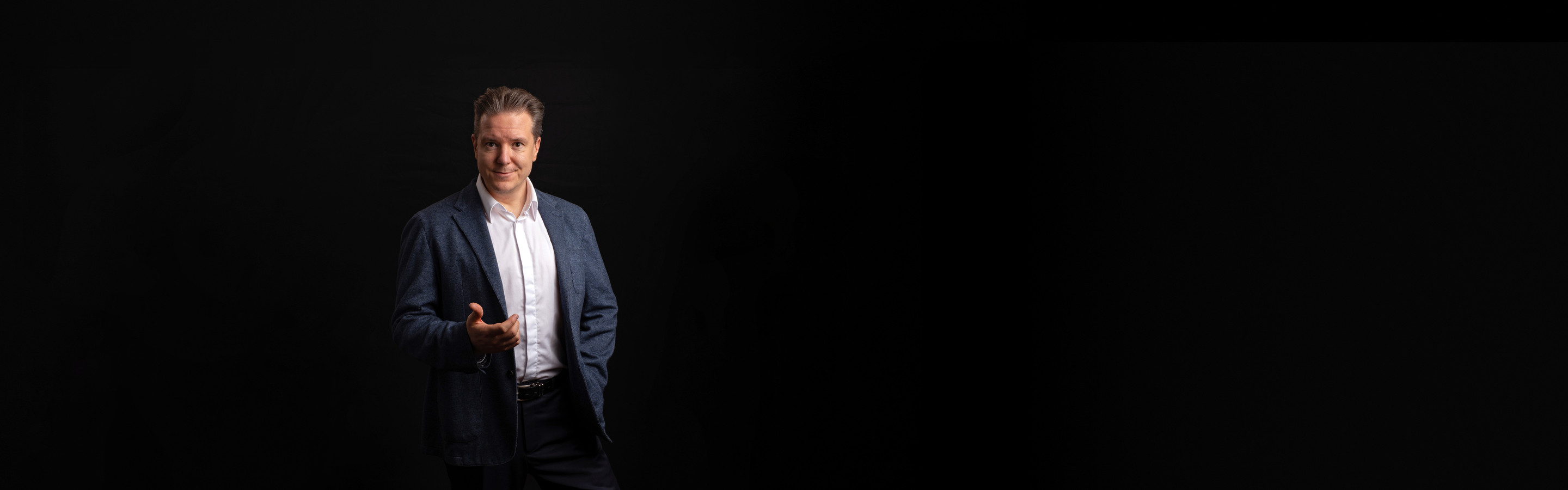 Ilkka Rajala sinisessä pikkutakissa ojentaa kättään