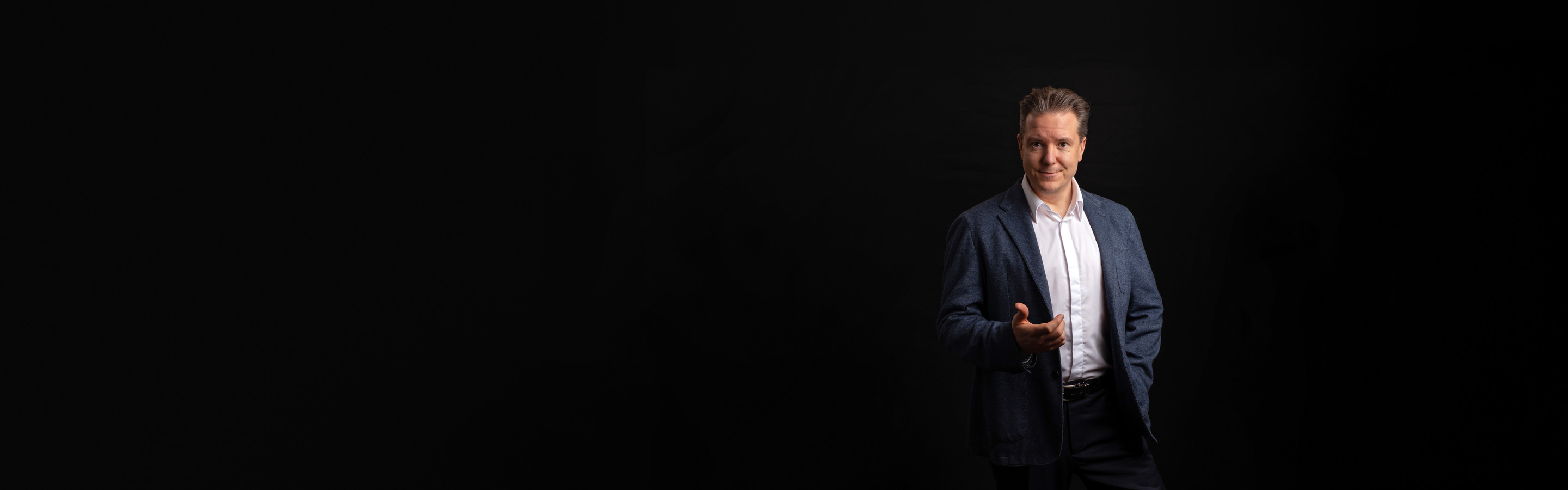 Ilkka Rajala sinisessä pikkutakissa ojentaa kättään